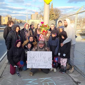 A family photo showing relations of Ken McEldowney holding a memorial for him on Wyandotte Street West between Crawford and Caron Avenue in Windsor on March 27, 2022.