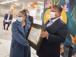 Madelyn Della Valle (left), curator of Museum Windsor, and Windsor Regional Hospital CEO David Musyj with a framed thank-you note from Premier Doug Ford at the mass COVID-19 vaccination center at the Devonshire Mall on March 29, 2022.