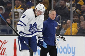 Maple Leafs' Justin Holl is led off the ice by a trainer after being cut during the second period against the Boston Bruins at TD Garden.  WINSLOW TOWNSON/USA TODAY SPORTS