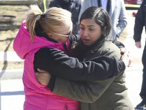 Bismah Ali (right) is consoled by neighbor Tina Huszar outside the Conestoga Dr. home where her brother, sister-in-law, two nieces, and nephew died in a fire on March 28, 2022. JACK BOLAND/TORONTO SUN
