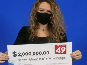 Sonia Correia-Batista holds the check for the Ontario 49 jackpot she and 15 other nurses won.