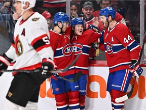 Canadiens' Cole Caufield, center, celebrates his goal with teammates Nick Suzuki, left, and Joel Edmundson during the second period against the Ottawa Senators at the Bell Center on Saturday, March 19, 2022, in Montreal.