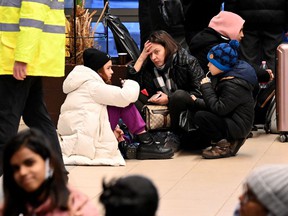 A woman with two children and foreign students from Ukrainian universities wait for their train at the railway station in Zahony, Hungary, close to the Hungarian-Ukrainian border.