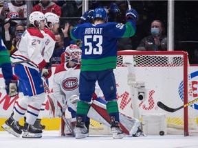 The Canucks' Bo Horvat celebrates Brock Boeser's goal against Canadiens goalie Sam Montembeault during second period Wednesday night in Vancouver.