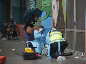 Paramedics help a man suffering a drug overdose on Columbia Street in Vancouver's Downtown Eastside Saturday, May 2, 2020.