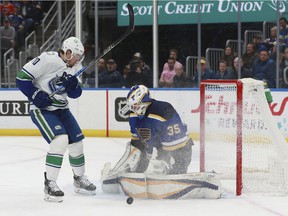 St. Louis Blues goalie Ville Husso (35) makes a save against Vancouver Canucks' Tanner Pearson (70) during the first period of an NHL hockey game Monday, Mar. 28, 2022, in St. Louis.