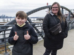 Cash Mathieson, 10, and mom, Jennifer Mathieson, discuss the lifting of COVID-19 restriction on the North Vancouver waterfront on Thursday.