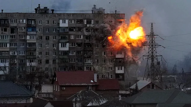 An explosion is seen in an apartment building after tank fire from Russian forces in Mariupol, Ukraine, on Friday. (Evgeniy Maloletka/The Associated Press)