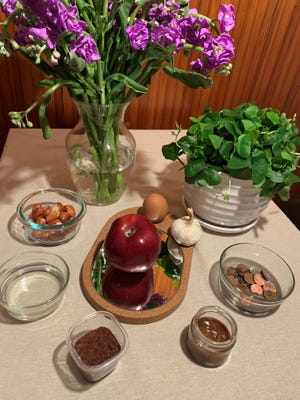 Table traditionnelle à demi-vue.  De gauche à droite : Fleurs, trèfle, pièces de monnaie, samanu, sumac, vinaigre, senjed.  Centre : pomme, œuf et ail sur un miroir.