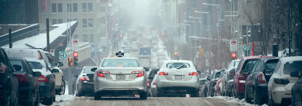Des voitures roulent en hiver dans la rue.