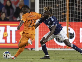 Houston Dynamo FC forward Darwin Quintero (23) strikes the ball against Vancouver Whitecaps FC midfielder Leonard Owusu (17) in the first half at PNC Stadium.  Photo: Thomas Shea-USA Today Sports