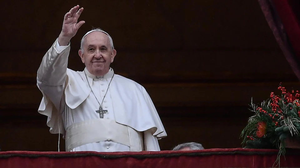 Le pape François salue la foule de la main, depuis le balcon du Vatican.