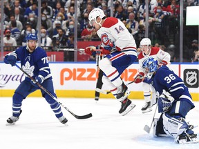 Canadiens' Suzuki (14) jumps as he attempts to screen a shot on Maple Leafs goalie Jack Campbell at Scotiabank Arena on Oct. 13, 2021, in Toronto.