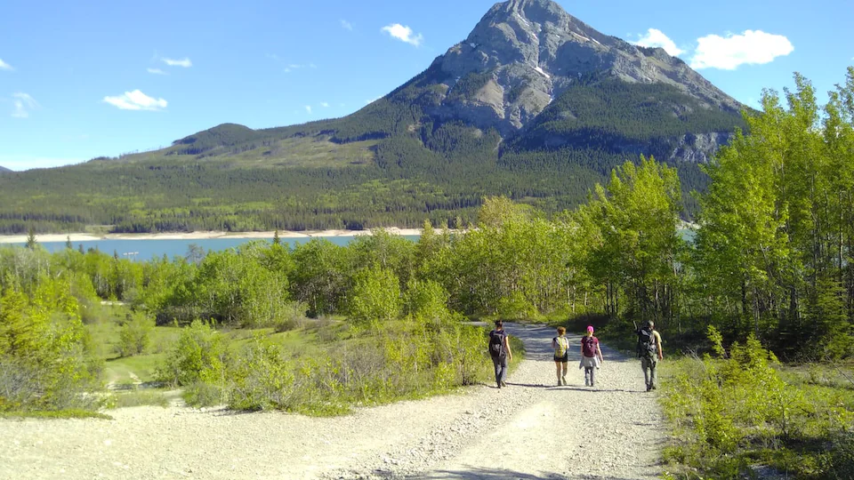 Des personnes marchent sur un sentier avec le mont Baldy et le lac Barrier en arrière-plan. 