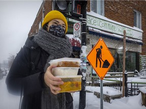 Alison Lee carries her food order from the Parc-Ex Curry Collective, picked up from La Place Commune café.  Customers such as Lee have the option to also buy meals for residents experiencing food insecurity.