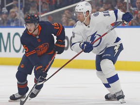 Edmonton Oilers forward Josh Archibald (15) and Tampa Bay Lightning forward Corey Perry (10) look for a loose puck during the first period at Rogers Place.