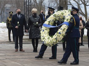 Health workers carry a wreath as Quebec Premier François Legault, left, and his wife Isabelle Brais look on during a ceremony for the victims of COVID-19, Thursday, March 11, 2021 at the legislature in Quebec City.