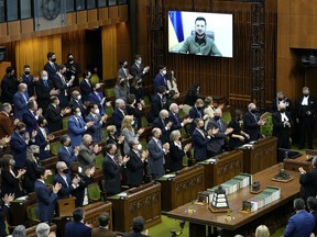 Le président ukrainien Volodymyr Zelenskyy reçoit une ovation debout alors qu'il se présente par vidéoconférence pour s'adresser au Parlement, à la Chambre des communes sur la Colline du Parlement à Ottawa, le mardi 15 mars 2022. LA PRESSE CANADIENNE/Justin Tang
