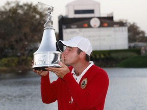 Scottie Scheffler is awarded the championship trophy after winning the Arnold Palmer Invitational golf tournament in Orlando, Fla., March 6, 2022.