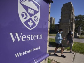 Students wearing face masks walk across campus at Western University in London on Sept.  19, 2020.