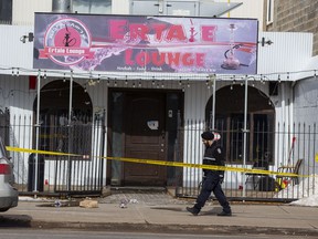 An Edmonton Police Service member investigates the scene of a suspicious death of an adult male following a shooting at a lounge on 118 Avenue near 125 Street on Saturday, March 12, 2022 in Edmonton.