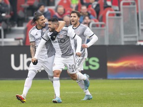 Toronto FC midfielder Alejandro Pozuelo (10) celebrates scoring a goal with Toronto FC defender Carlos Salcedo (3) during the first half against DC United at BMO Field on Saturday.