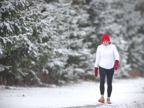 Mary-Ann Rennie goes for a run with her tuque and mittens at Optimist Memorial Park as snow blanketed the region on Friday, March 11, 2022.