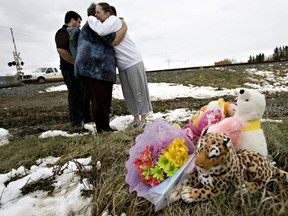 Staff from Winterburn School hug at a memorial next to the crash scene that killed John Baxter and his two daughters, Julianne and Coral Sky, at 215 Street and 112 Avenue.  The truck the occupants were riding in collided with a Via Rail passenger train on their way to school on May 4, 2010.