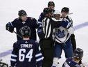 Toronto Maple Leafs' Wayne Simmonds (24) is held back by officials as he tries to get to Winnipeg Jets' Logan Stanley (64) during the third period of NHL action in Winnipeg on December 5, 2021.  