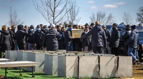 As mourners say goodbye to a family of five killed early Monday morning when a fire erupted in their Brampton home, a coffin is carried to one of five burial vaults at Brampton Funeral Home & Cemetery in Brampton, Ont.  on Saturday April 2, 2022.
