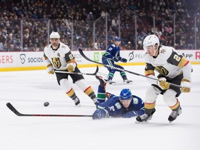 Vancouver Canucks' Vasily Podkolzin (92) dives to knock the puck away from Vegas Golden Knights' Zach Whitecloud (2) during the first period of an NHL hockey game in Vancouver, BC, Sunday, April 3, 2022.