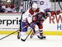 Montreal Canadiens defenseman Justin Barron battles for the puck with New Jersey Devils center Jack Hughes during the third on March 27, 2022, in Newark, NJ