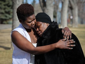 Jal Acor Jal's mother Achang Jal and grandmother Abuk Diiene comfort themselves after speaking to the media in Calgary on Wednesday, April 6, 2022. Police said Wednesday they have arrested the 16-year-old.