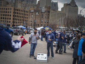 Tiger fans play a game of corn hole while tailgating outside Comerica Park in downtown Detroit where the Detroit Tigers are hosting the Chicago White Sox in the home opener to kick off the 2022 season of Major League Baseball, on Friday, April 8, 2022.