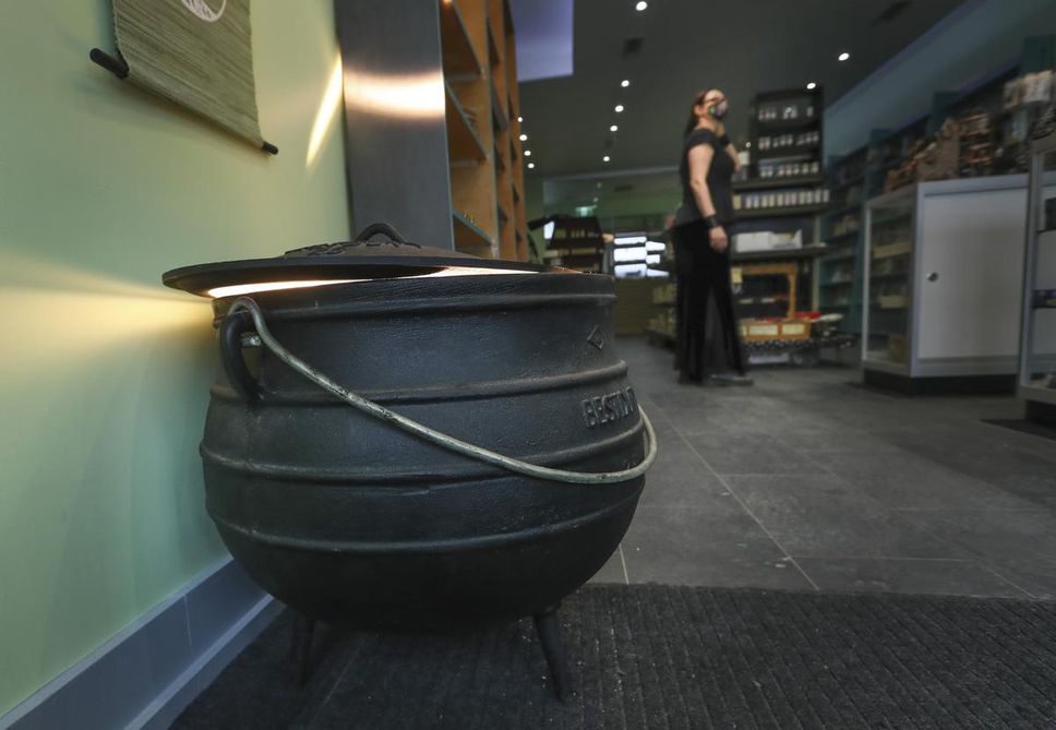 A cauldron sits on the floor at the Occult Shop.