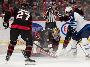 Ottawa Senators goalie Mads Sogaard (33) makes a save in front of Winnipeg Jets center Mark Scheifele (55) in the first period at the Canadian Tire Center.