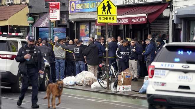 El personal del departamento de policía de la ciudad de Nueva York se reúne en la entrada del metro. x20;parada en el distrito de Brooklyn de Nueva York el martes 12 de abril de x20;2022.