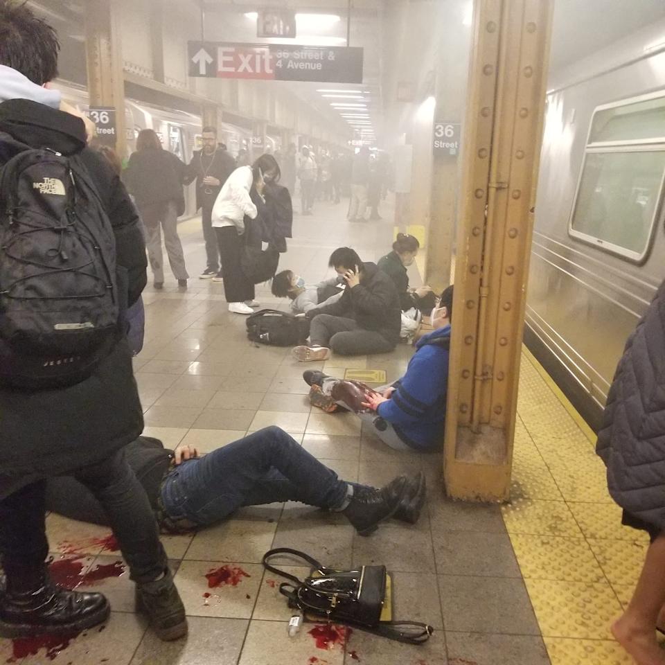 The wounded stand up, sit down and lie down on the platform of a smoke-filled subway station.