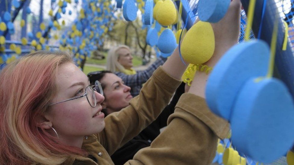 Ukrainians hang symbolic blue and yellow eggs in Lviv