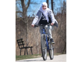 Jana Jandal Alrifai, 19, is shown on her bike near her south Windsor home on Saturday, April 16, 2022. She says the city needs more bike lanes.