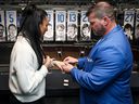Maple Leafs superfan Mark Fera (right) puts a ring on his girlfriend Rita Marini's finger after proposing to her at the Scotiabank Arena Tuesday.