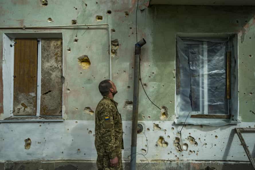 A Ukrainian soldier checks the destruction of the shrapnel in a wall of a village near the front lines of Mykolaiv after Russian shelling at night, in Ukraine.
