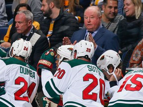 Then-Minnesota Wild head coach Bruce Boudreau talks to his team while his assistant Dean Evason (left) looks on during an October 2018 NHL game in Nashville against the Predators.  Evason took over as head coach when Boudreau was fired in February 2020.