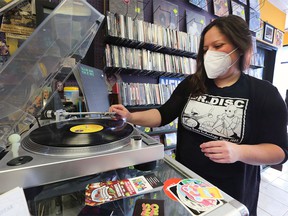 Aimee Charette, manager of downtown Windsor's Dr. Disc Records, puts an LP on a turntable on April 20, 2022.