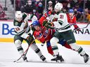 Montreal Canadiens winger Brendan Gallagher tries to squeeze past Minnesota Wild's Mitchell Chaffee, left, and Brandon Duhaime during the second period at the Bell Center in Montreal on April 19, 2022.