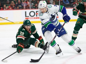 Apr 21, 2022;  Saint Paul, Minnesota, USA;  Vancouver Canucks right wing Alex Chiasson (39) controls the puck while Minnesota Wild right wing Ryan Hartman (38) defends during the first period at Xcel Energy Center.
