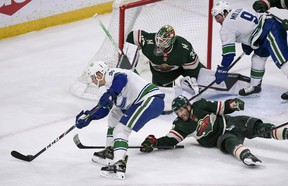 Vancouver Canucks right winger Alex Chiasson, left, tries to get the puck past Minnesota Wild right wing Ryan Hartman, right, and goalie Cam Talbot during the first period of an NHL hockey game Thursday, April 21, 2022, in St. Paul, Minn .