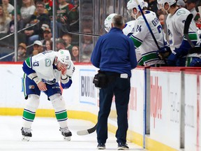 Vancouver Canucks right wing Brad Richardson (13) leaves the ice after receiving a high stick by Minnesota Wild left wing Kirill Kaprizov during the first period at Xcel Energy Center.  Canucks coach Bruce Boudreau said that Richardson broke his nose.