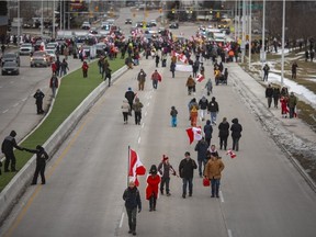 Protesters, who are mostly not part of the original blockade, mingle freely up and down Huron Church Road late in the afternoon after police cleared a portion of the Ambassador Bridge blockade, on Saturday, February 12, 2022.