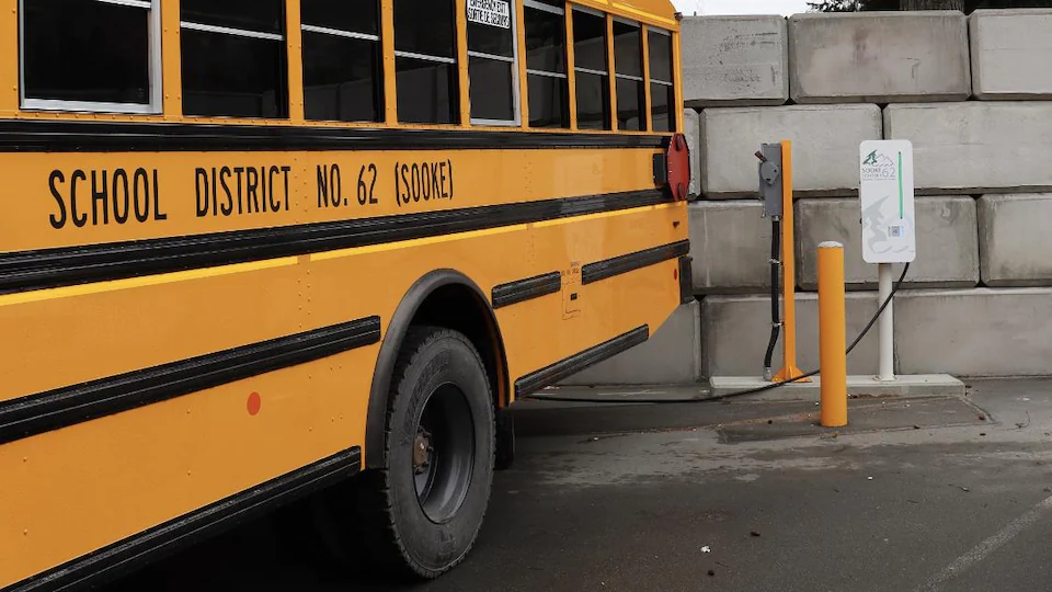 Un autobus scolaire jaune électrique est en train de charger ses batteries.